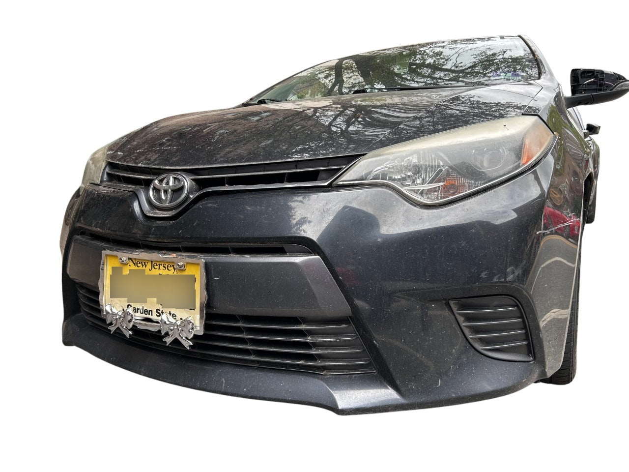 Decorative chrome license plate frame with sculpted bow details installed on a car, standard U.S. fit